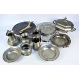 A group of pewter items including a set of six plates, a tureen with cover, and jugs,