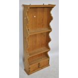 A set of 20th century pine shelves with twin cupboard doors to base, height 125.5cm, width 55.5cm.