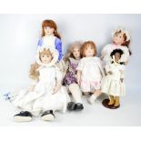 A group of bisque porcelain headed dolls, the majority with glass eyes and painted features,