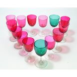 A harlequin set of twelve cranberry tinted and clear glass wine glasses and pair of similar green