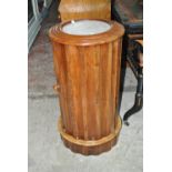 A Victorian walnut cylindrical pot cupboard, the top inset with marble above single door,