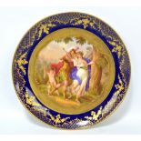 A Vienna style porcelain circular cabinet plate 'Rinaldo and Almida' within gilt heightened cobalt