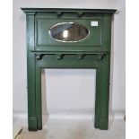 A green painted Edwardian fire surround with moulded mantel above bevelled oval mirror,