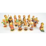 A group of over fifteen Hummel figures of children in varied poses and outfits.