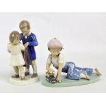 A Lladro figure of a kneeling boy playing with a toy train (af) and a B & G Copenhagen figure group