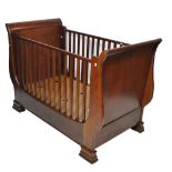 A child's reproduction mahogany sleigh bed with slatted side supports.