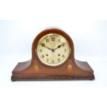 An Edwardian mahogany and inlaid domed mantel clock, the circular dial set with Arabic numerals,