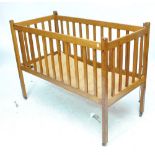 An oak crib raised on square supports to castors, length 125cm.