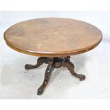 A late 19th century oval walnut loo table with inlaid motifs,