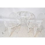 A garden set of white painted table with glass top and four chairs (5).