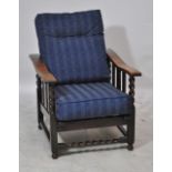 An early 20th century oak reclining elbow chair with two blue upholstered cushions.