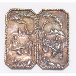 A Chinese export silver two piece belt buckle decorated with scenes of figures in a landscape,