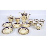 A Noritake six setting coffee set decorated with gilt floral and foliate motifs on a blue and cream