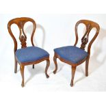 A set of six Victorian mahogany splat back chairs with carved foliate scroll detail and upholstered