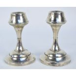 BOOTS PURE DRUG CO; a pair of George V hallmarked silver squat candlesticks,