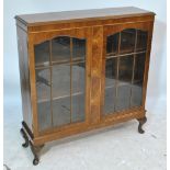 A reproduction walnut display cabinet with twin glazed doors, central simulated burr walnut panel,