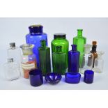 A group of various pharmaceutical blue, green and clear glass bottles, the largest height 19.5cm.