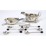 A small group of variously hallmarked silver items comprising a sauce boat with shaped rim,