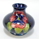 MOORCROFT; a 'Pansy' pattern tubeline decorated squat baluster vase,