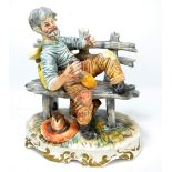 A Capodimonte figure, vagrant on a bench drinking wine, height 28cm.