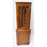 A reproduction yew wood freestanding corner cupboard with astragal glazed upper section above