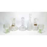 Four cut glass decanters of varying shapes, two with labels,