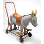 A Tri-ang child's push/ride-on toy modelled as a saddled donkey on four wheels, length 64.5cm.