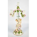 A late 19th century German porcelain three branch candelabra, with mother and child to the base,