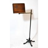 A Victorian brass and mahogany music stand on cast iron quadripartite base with paw feet,