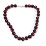 A cherry amber coloured bead necklace, length 49.5cm.