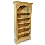 A 20th century pine open bookshelf with carved decoration, width 91cm.