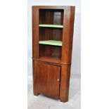 A teak freestanding corner cabinet with open upper section set with two painted shelves and a