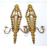 A pair of giltwood and mirrored semi-hexagonal girandoles with carved foliate decoration and two