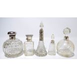 Five variously hallmarked silver mounted clear glass scent bottles to include a large globular