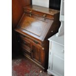 A late Victorian walnut bureau, the fall-front above a drawer and pair of doors, with key.