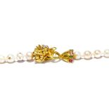 A string of cultured pearls with a 14ct yellow gold oriental dragon clasp set with diamonds,