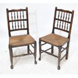 Four late 19th century spindle back chairs with rush seats and raised on tapering stretchered