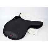 Equestrian interest; a large collection of padded numnahs and saddlecloths, mainly black and white,