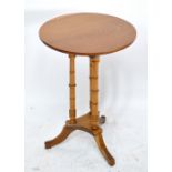 An early 20th century light oak circular topped occasional table on three turned and knopped