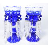 A pair of Victorian blue and clear glass table lustres with eight prisms, each below two blue drops,
