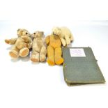 An early to mid-20th century straw filled teddy bear with stitched on mouth and glass eyes,