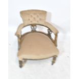 An Edwardian cream upholstered tub chair with carved scroll and swag detail on turned front legs to