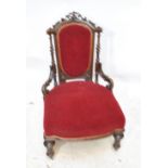 A Victorian walnut framed upholstered nursing chair with padded back and seat,