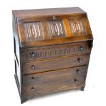 An early 20th century oak bureau with fall-front enclosing fitted interior above four long drawers,