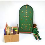 A marionette, a bagatelle board and a group of children's books.