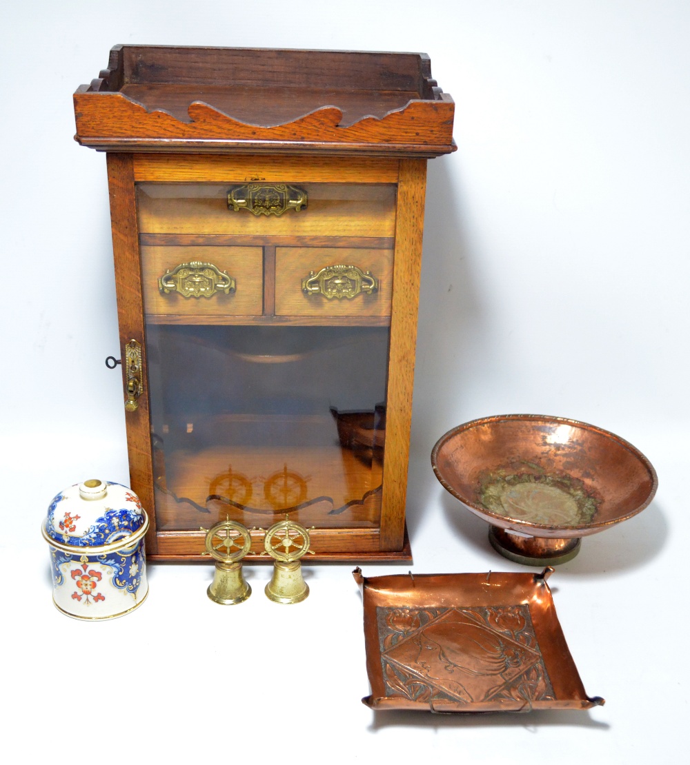 A circa 1900 oak smoker's cabinet with glazed door enclosing tobacco jar and pipe rack section