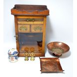 A circa 1900 oak smoker's cabinet with glazed door enclosing tobacco jar and pipe rack section