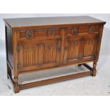 A reproduction oak sideboard with twin drawers above twin cupboard doors,