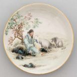 Plato circular en porcelana China. Trabajo Chino, Siglo XX. Decorado con anciano y cerdos. Marca en