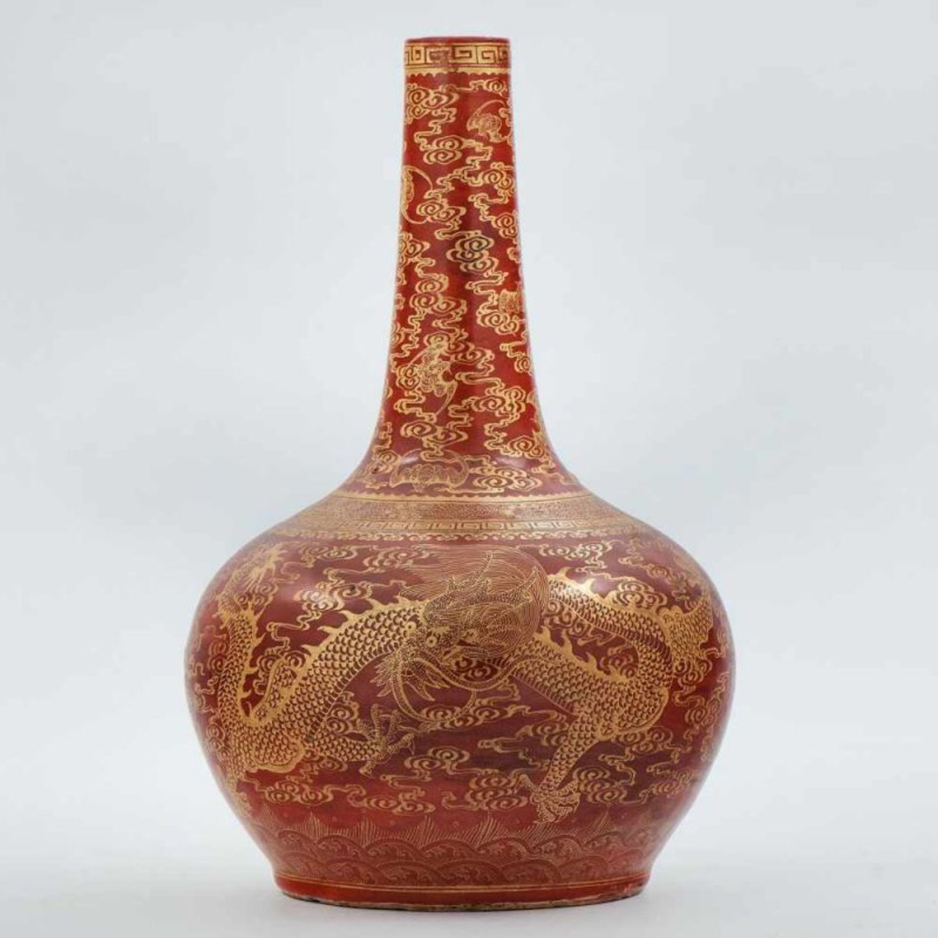 Jarrón chino en porcelana color rojo con motivos en dorado. Trabajo Chino, Siglo XX. Presenta